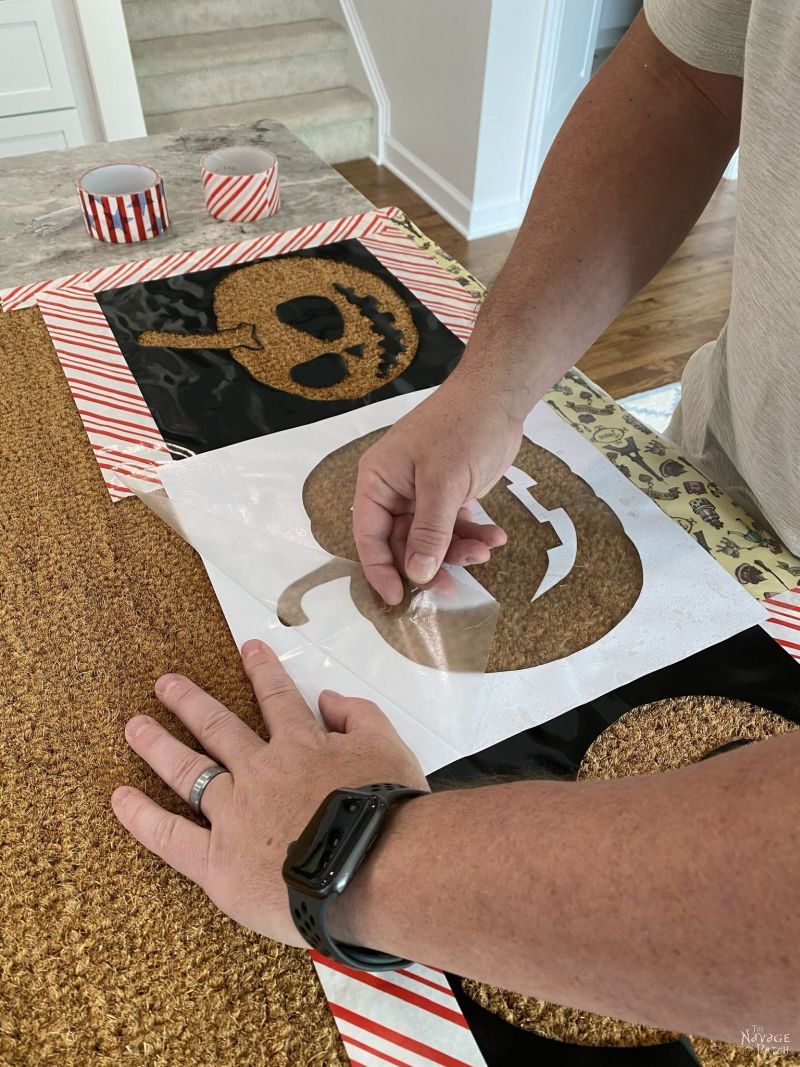 putting pumpkin stencils on a doormat