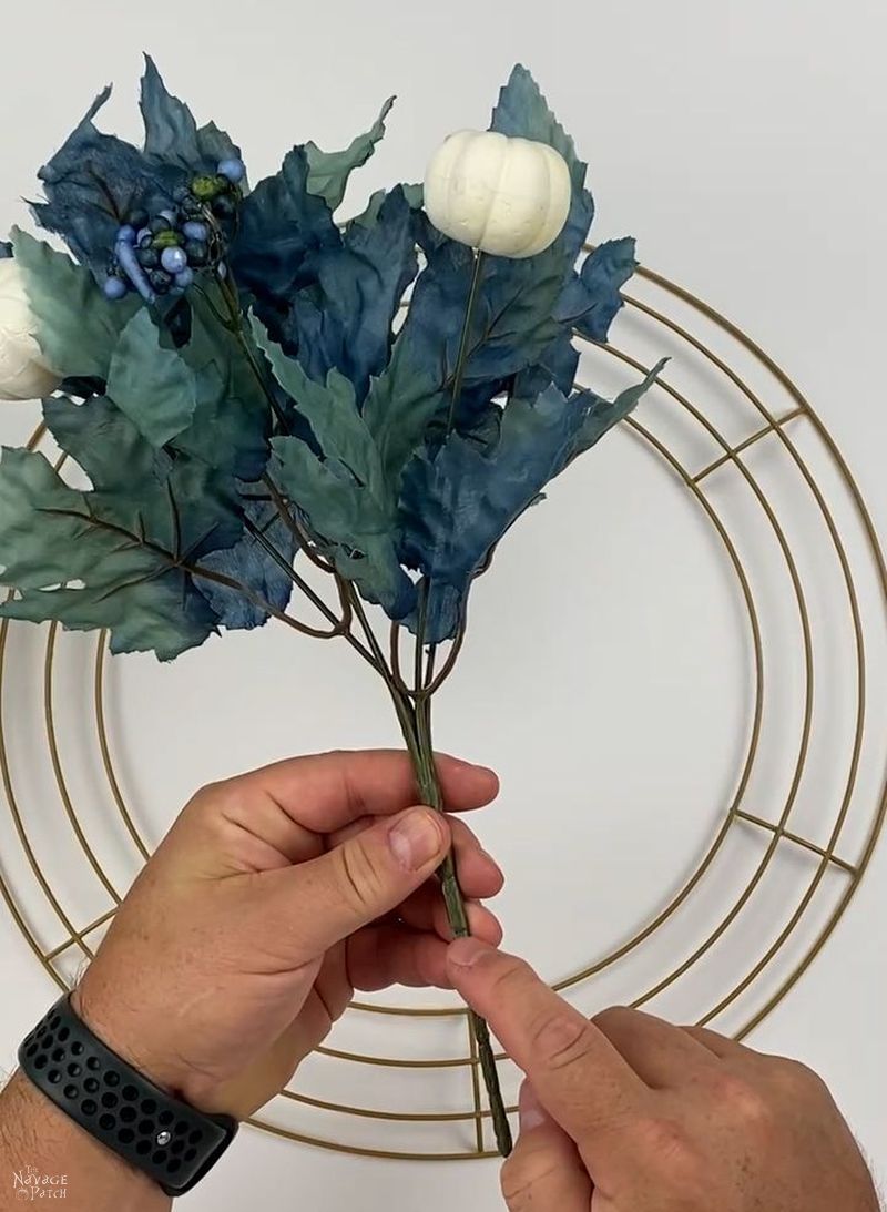 man holding a dollar tree floral pick