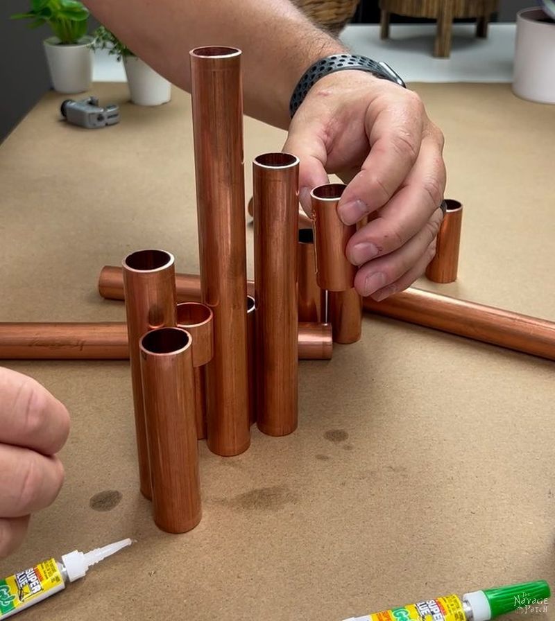man gluing copper pipes together