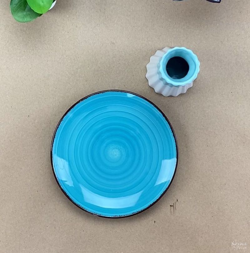 fluted vase and blue plate on a table