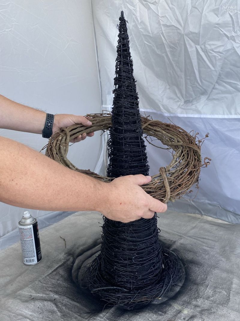 placing a grapevine wreath over a cone tree