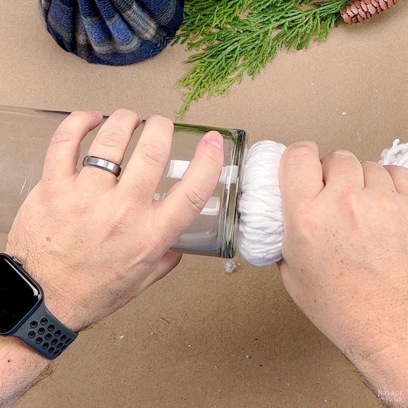 man gluing a mop head to a glass vase