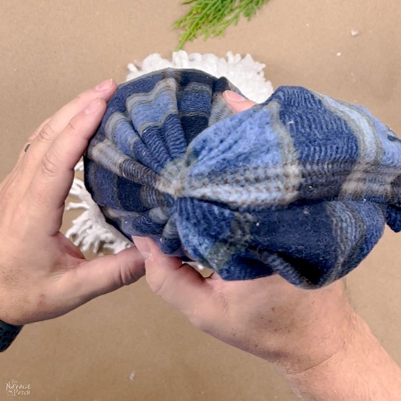 man putting a gnome hat onto a lighted mop gnome