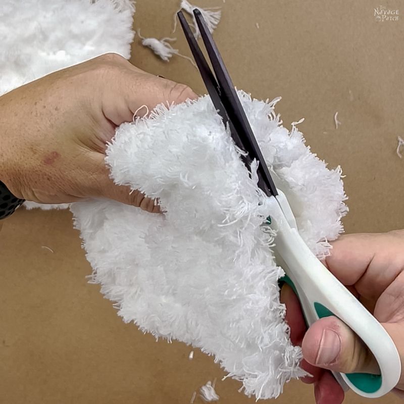 man cutting a dust mop head in half