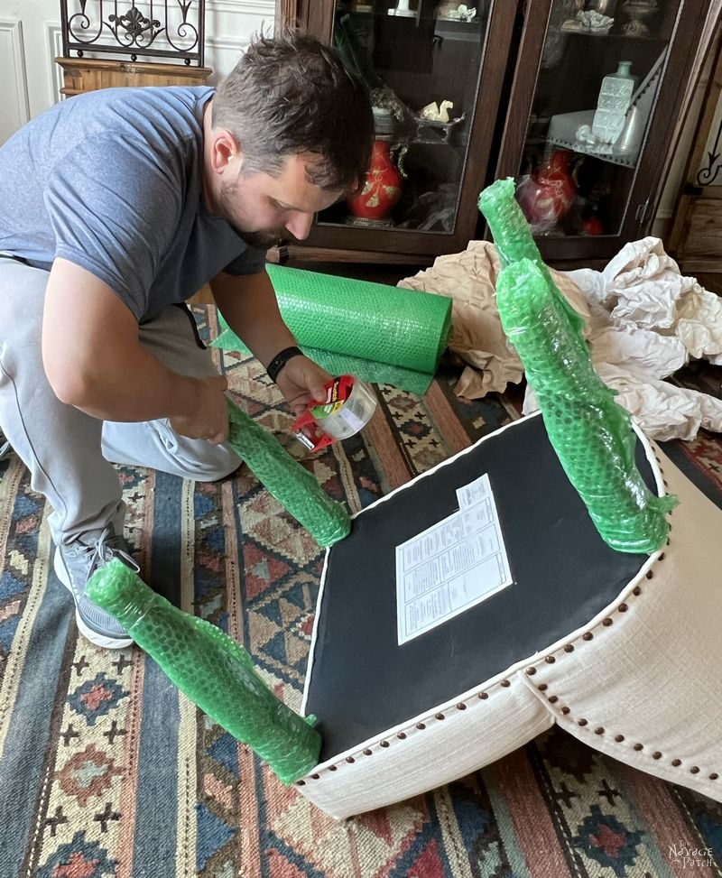 man wrapping dining room chair legs with bubble wrap - how to pack for a move