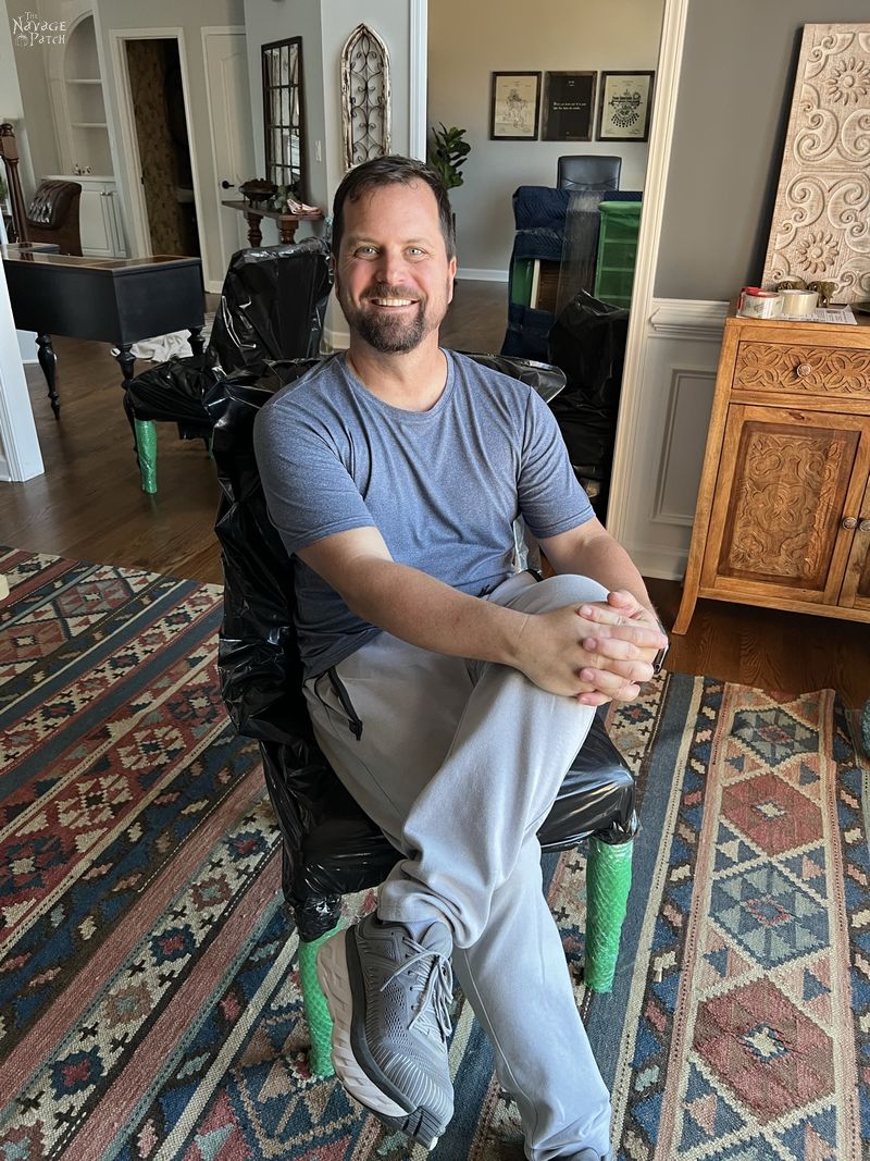 man sitting on a wrapped dining room chair