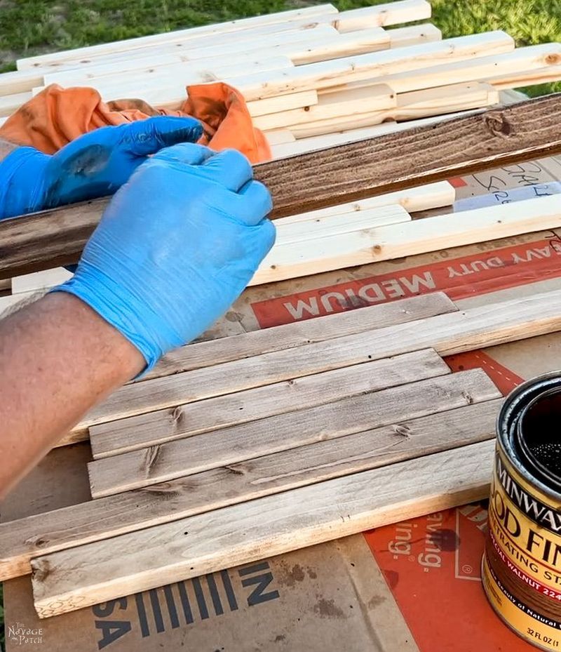 man staining furring strips