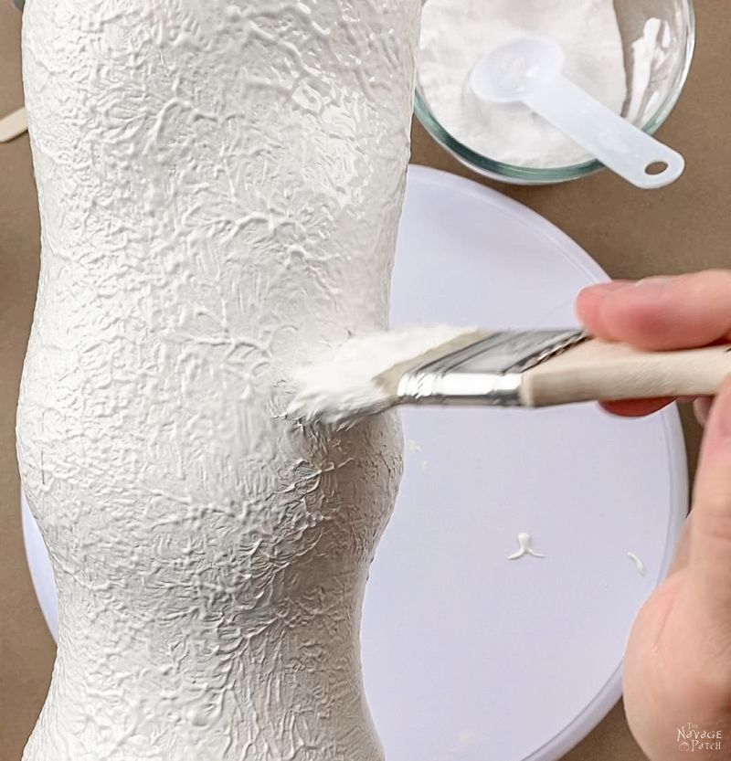 painting a vase with textured paint.