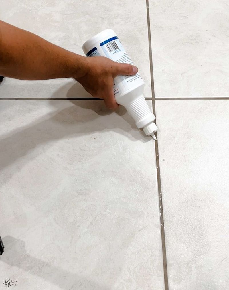 man applyting grout cleaner to dirty grout