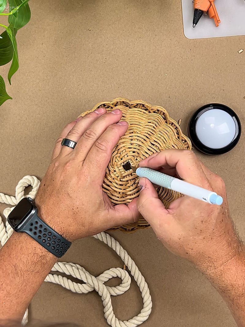 man cutting a hole in a rattan basket