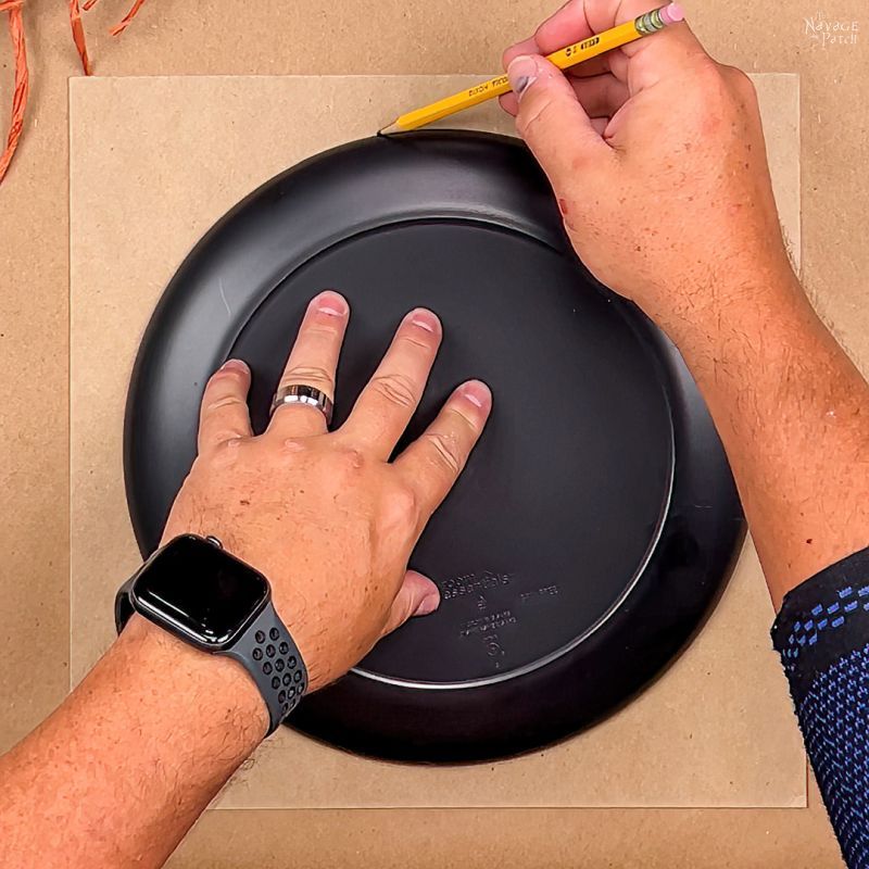 man tracing a circle onto a piece of chipboard