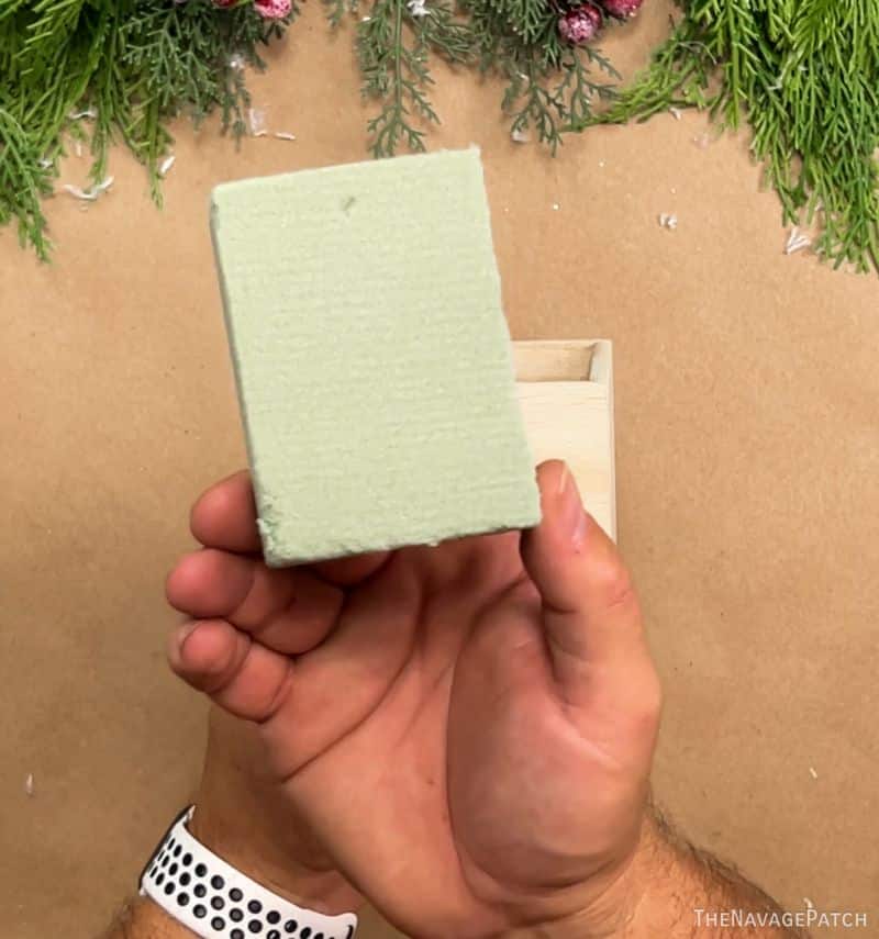 man holding a block of floral foam
