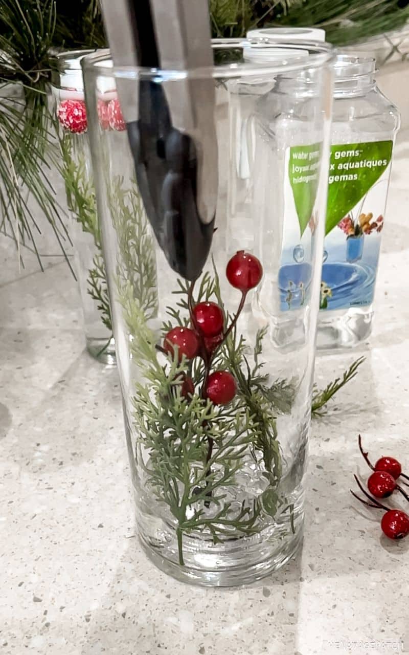 man adding greens to a vase