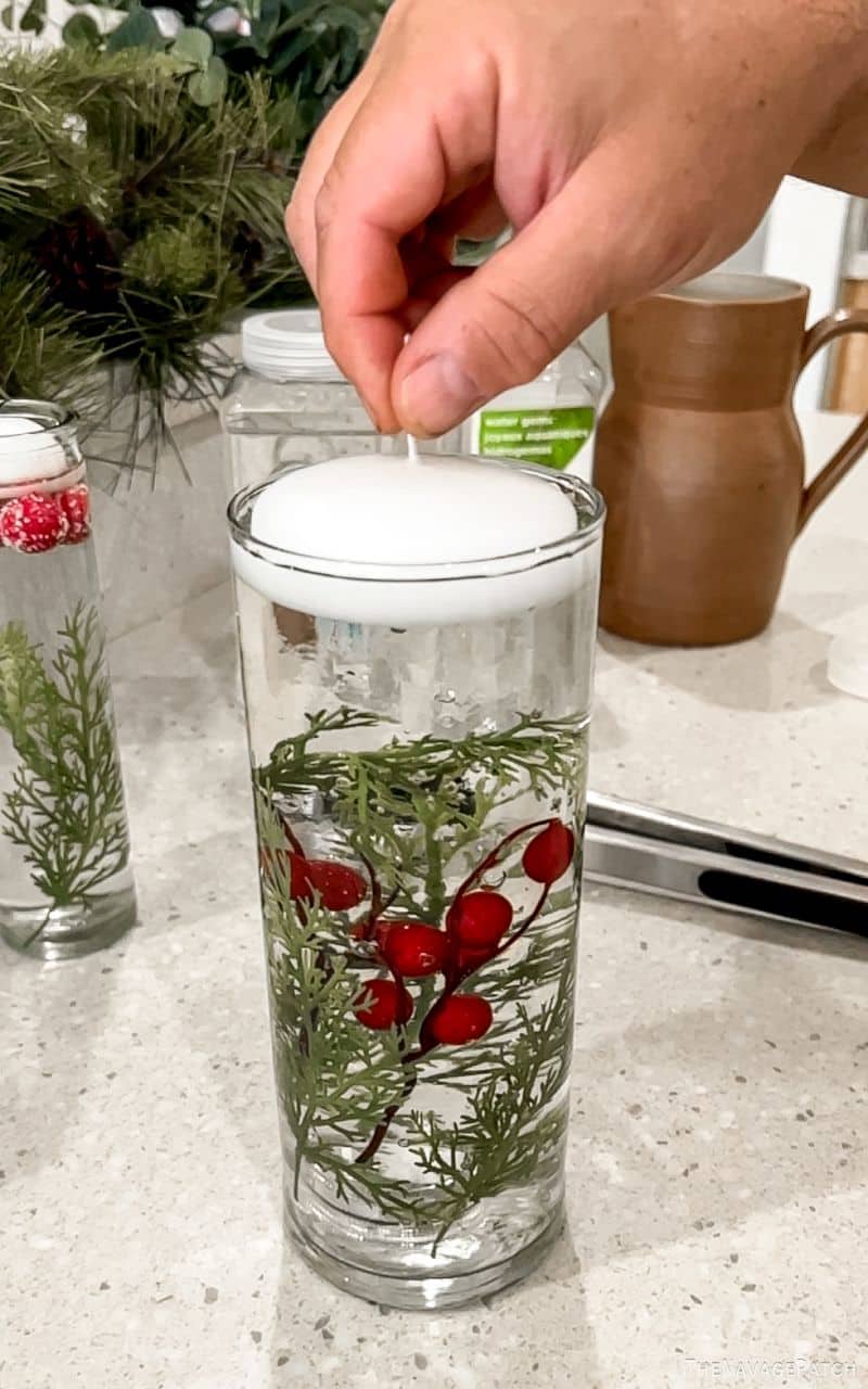 man putting a floating candle in a vase