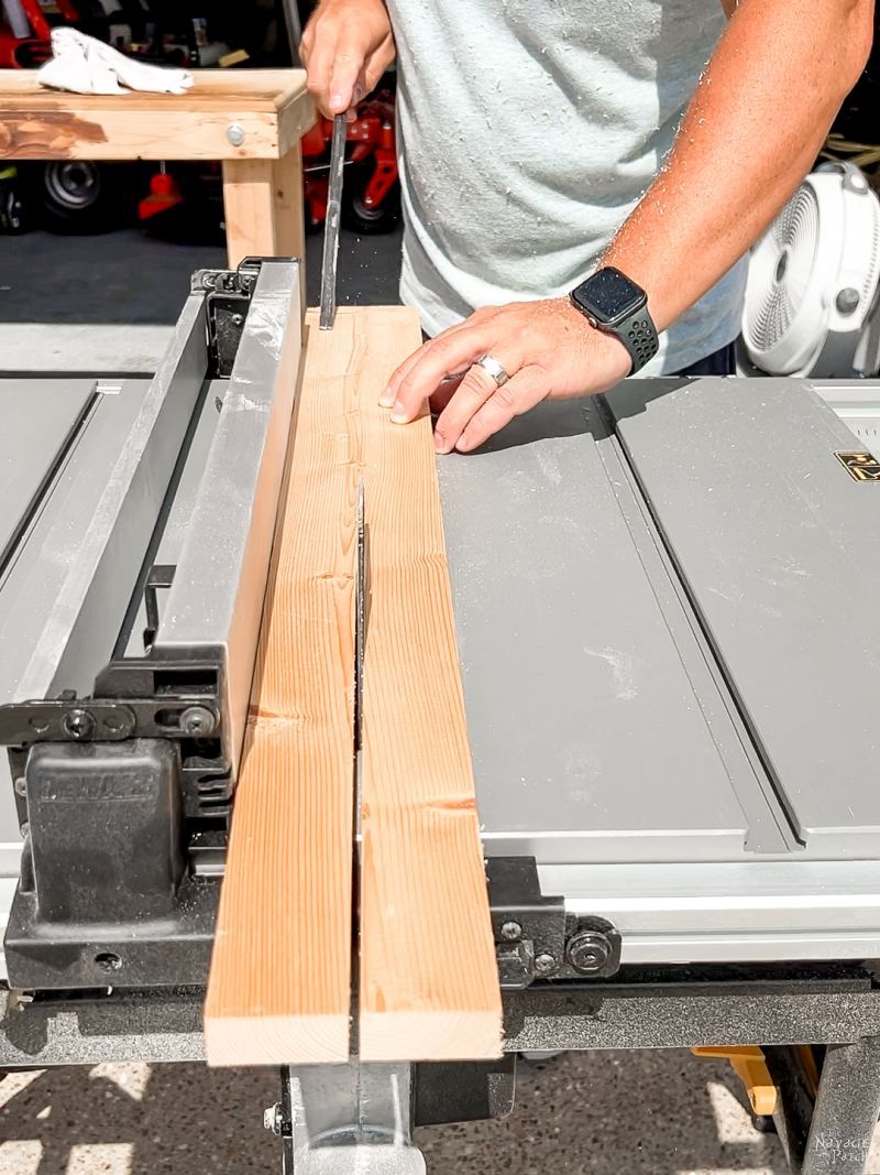 man cutting pine board on table say