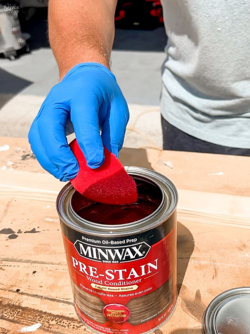 man putting pre-stain on pine