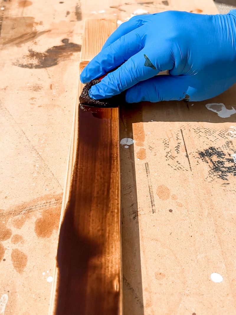 man staining pine boards