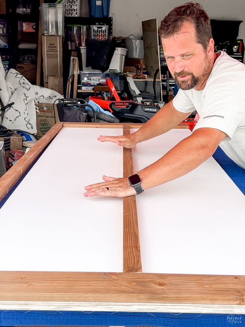 man pressing a slat onto a diy barn door