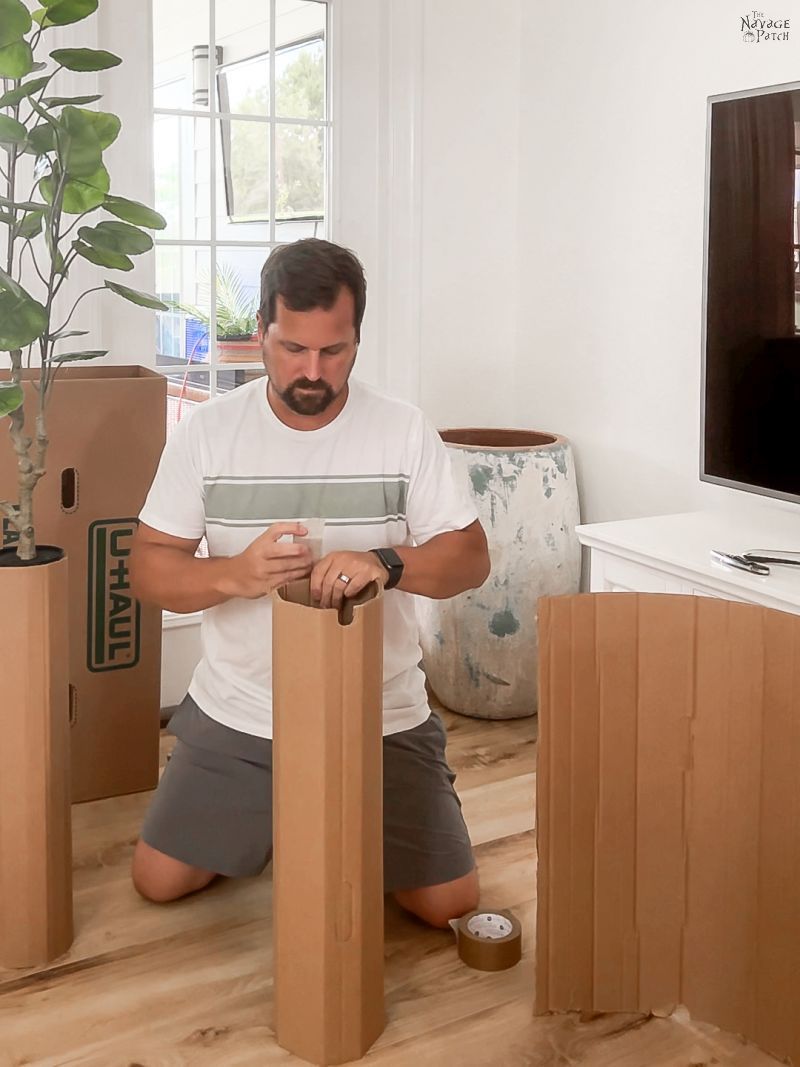 man taping cardboard cylinder