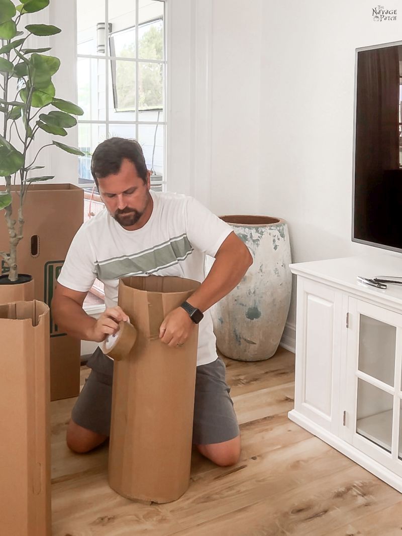 man taping cardboard cylinder