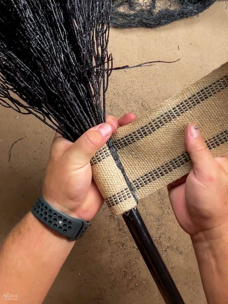 man wrapping a broomstick with twine