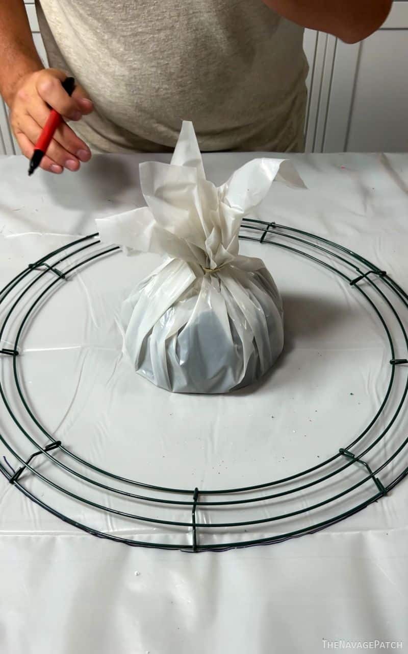 wreath form on table with plastic covered bowl in the middle