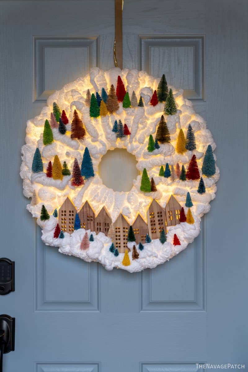 DIY Light-Up Snowy Village Wreath by TheNavagePatch.com