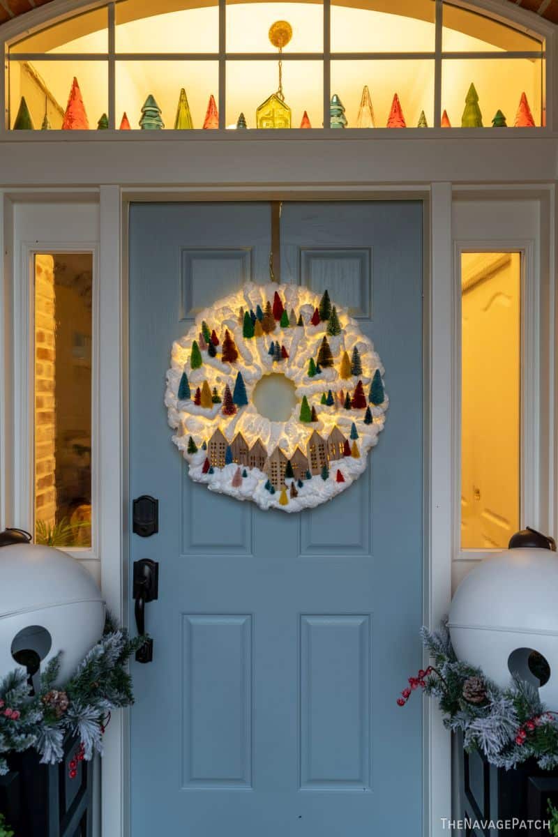 DIY Light-Up Snowy Village Wreath by TheNavagePatch.com