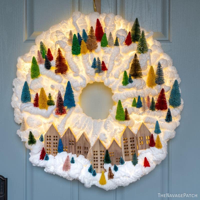DIY Light-Up Snowy Village Wreath by TheNavagePatch.com