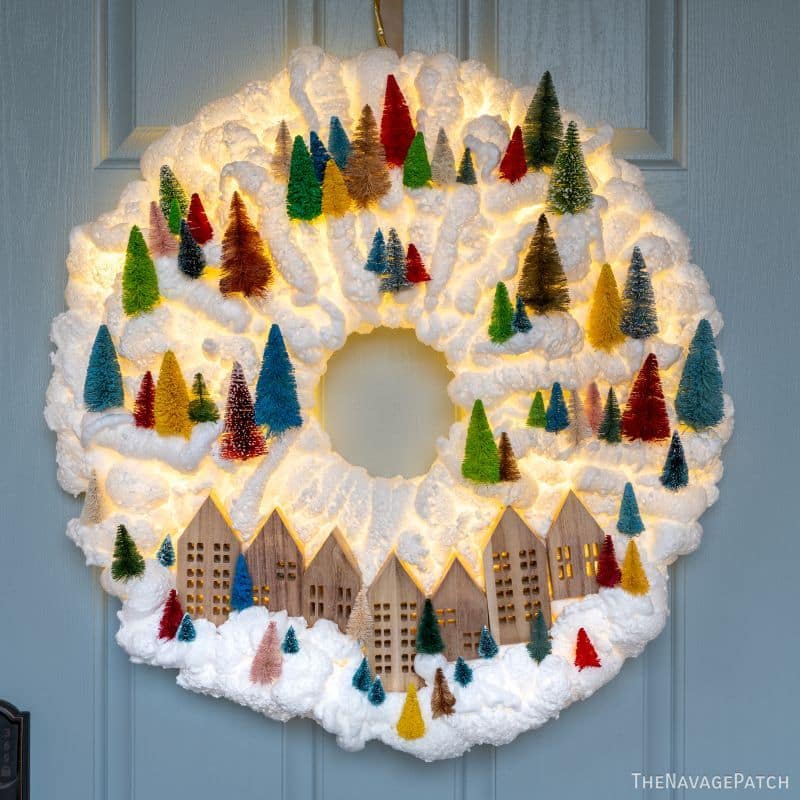 DIY Light-Up Snowy Village Wreath by TheNavagePatch.com