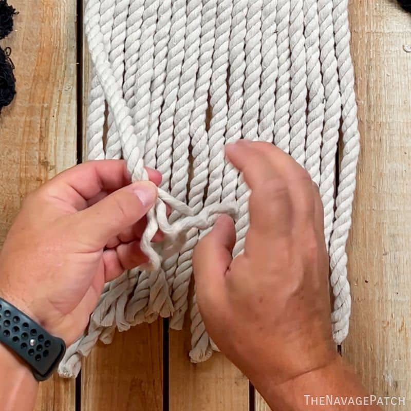 man untwisting rope