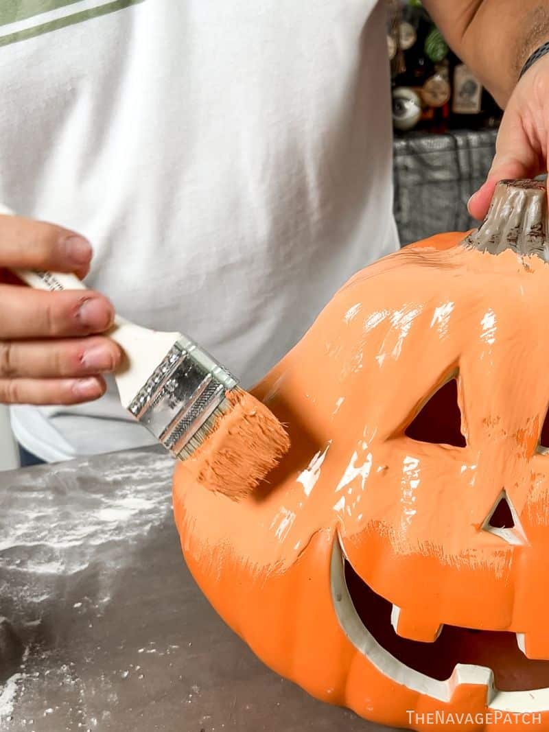 man painting a plastic pumpkin 