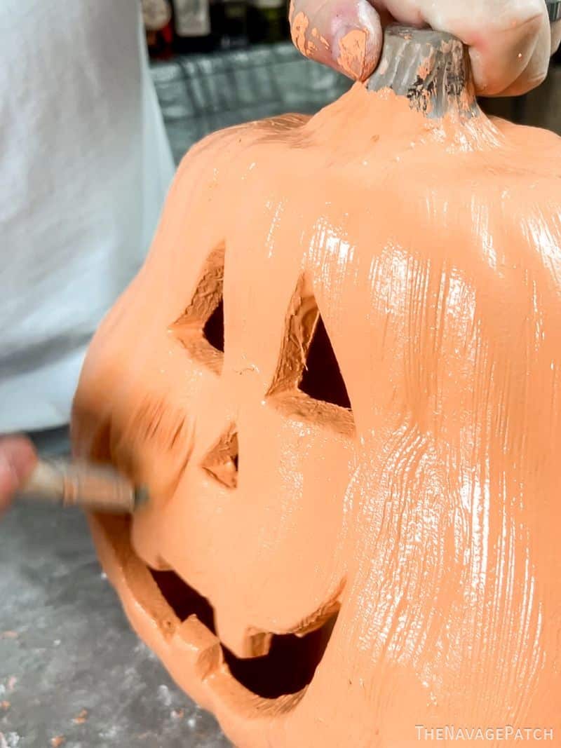 man painting a pumpkin