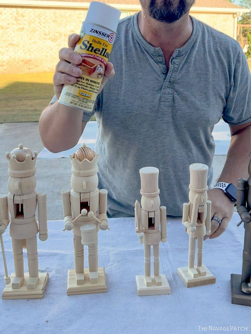 man holding shellac in front of nutcrackers