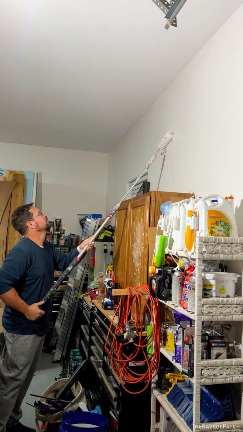 man painting a garage wall