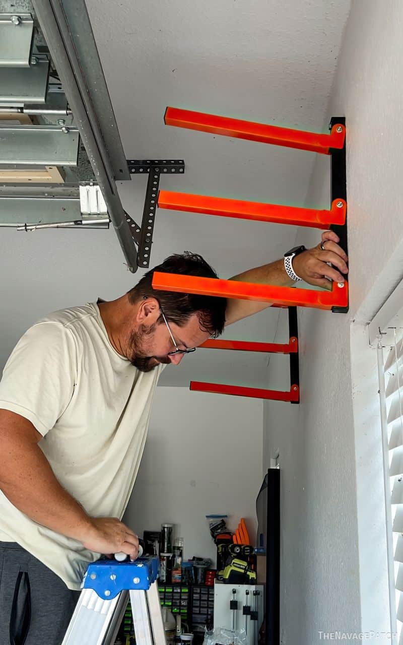 man installing wood storage racks in a garage