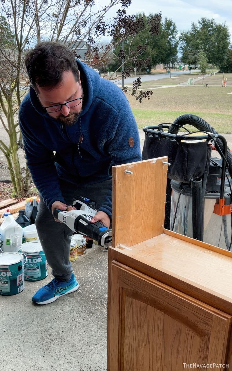 man cutting up some cabinets