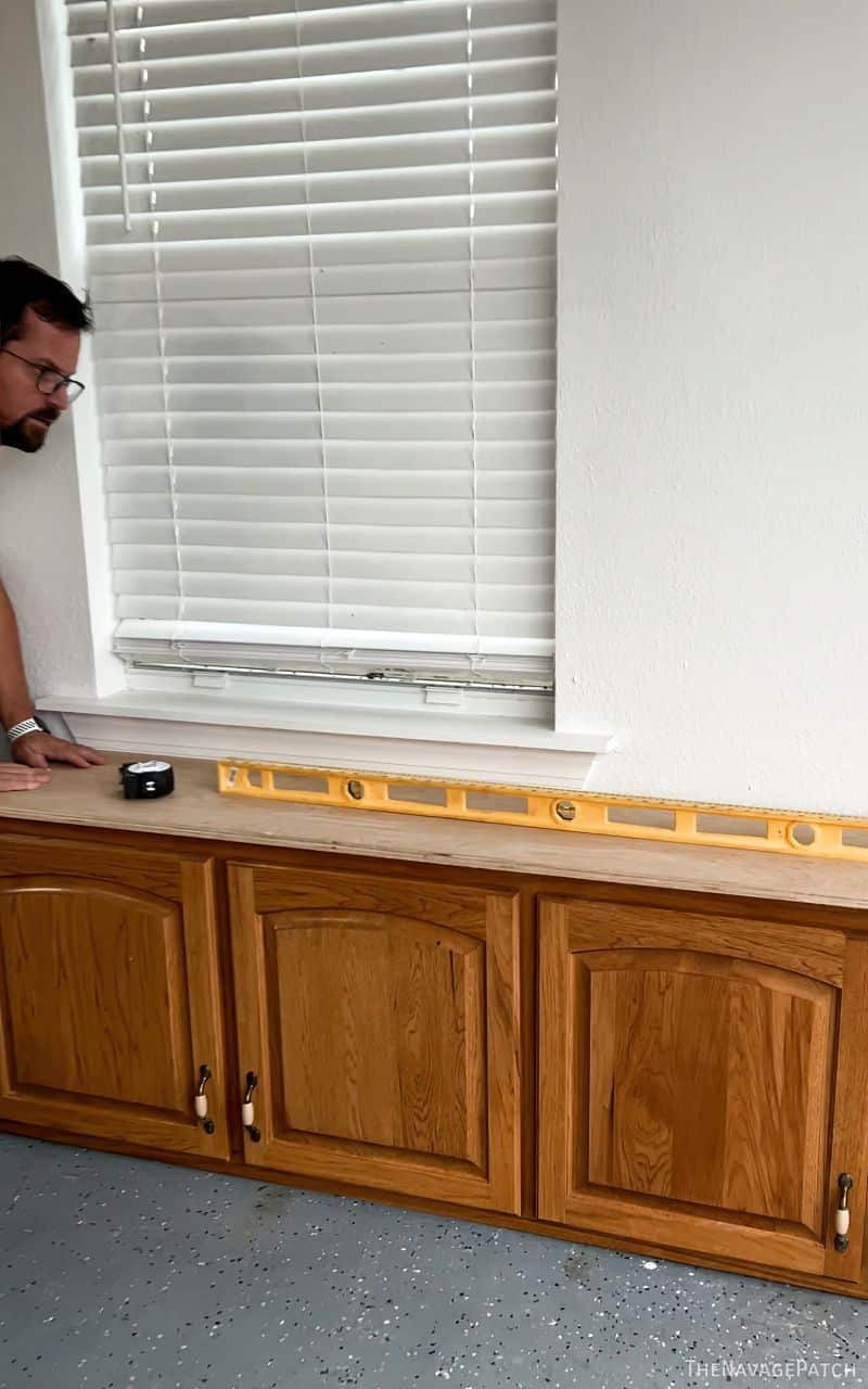 man installing diy cabinets in a garage