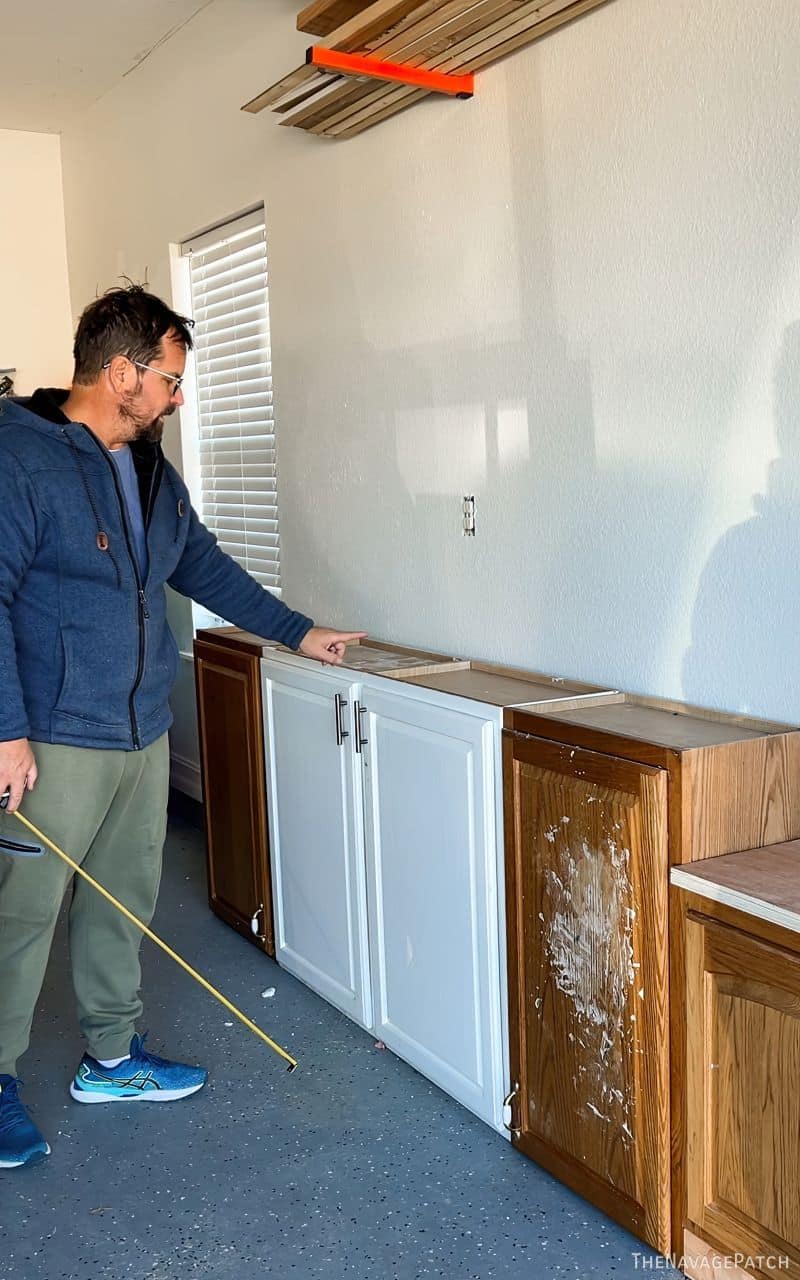 man installing cabinets in a garage