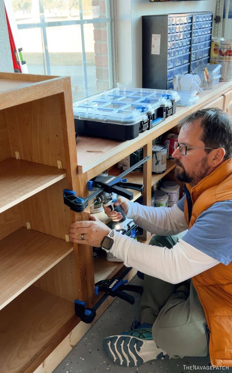 man screwing cabinets together