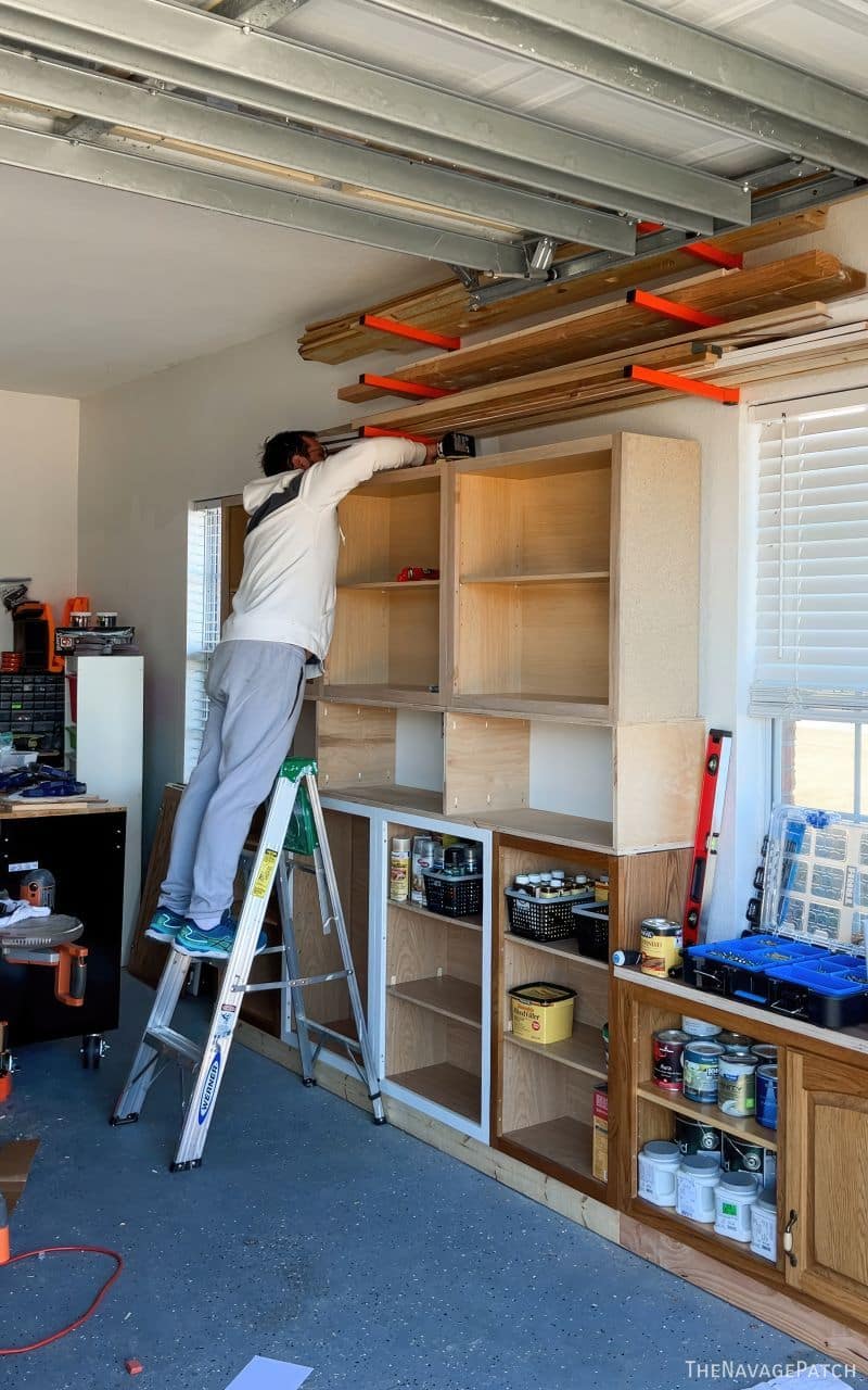 man installing garage cabinets