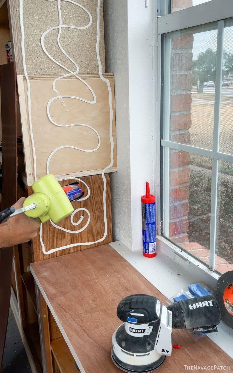 man putting adhesive on cabinets