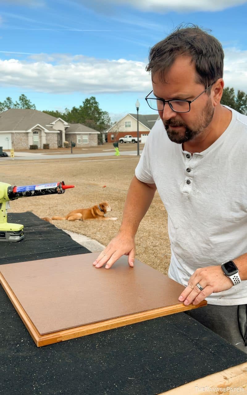 man gluing hardboard onto cabinet doors