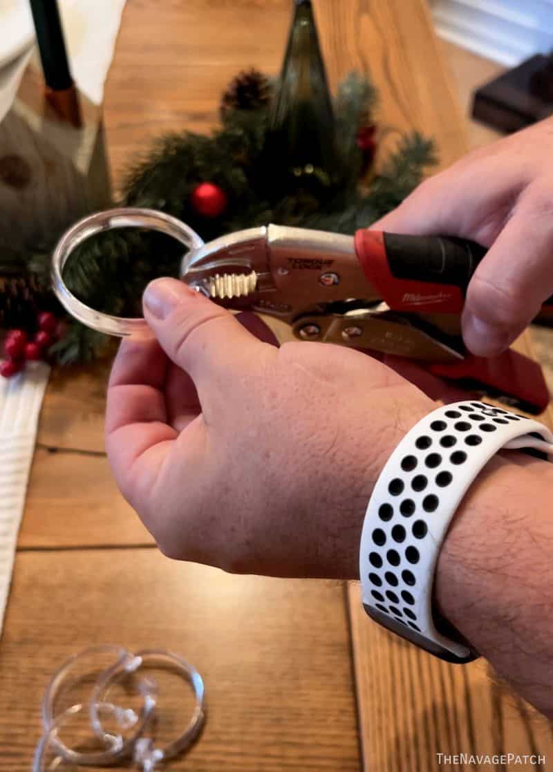 man using pliers on a shower curtain ring