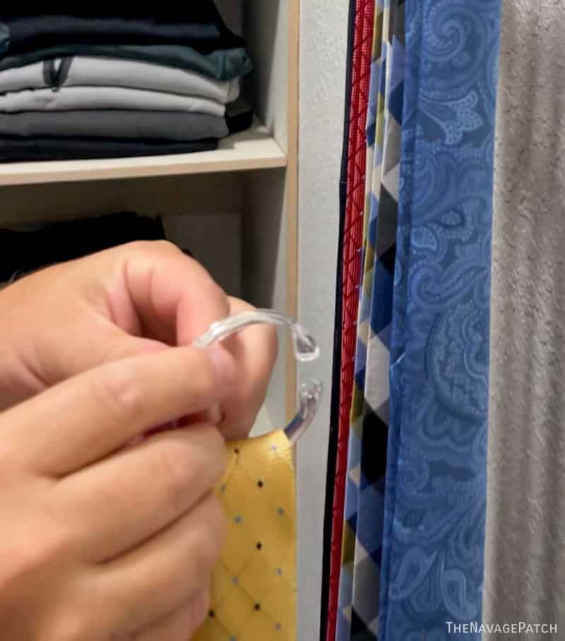 man putting a tie on a tie organizer