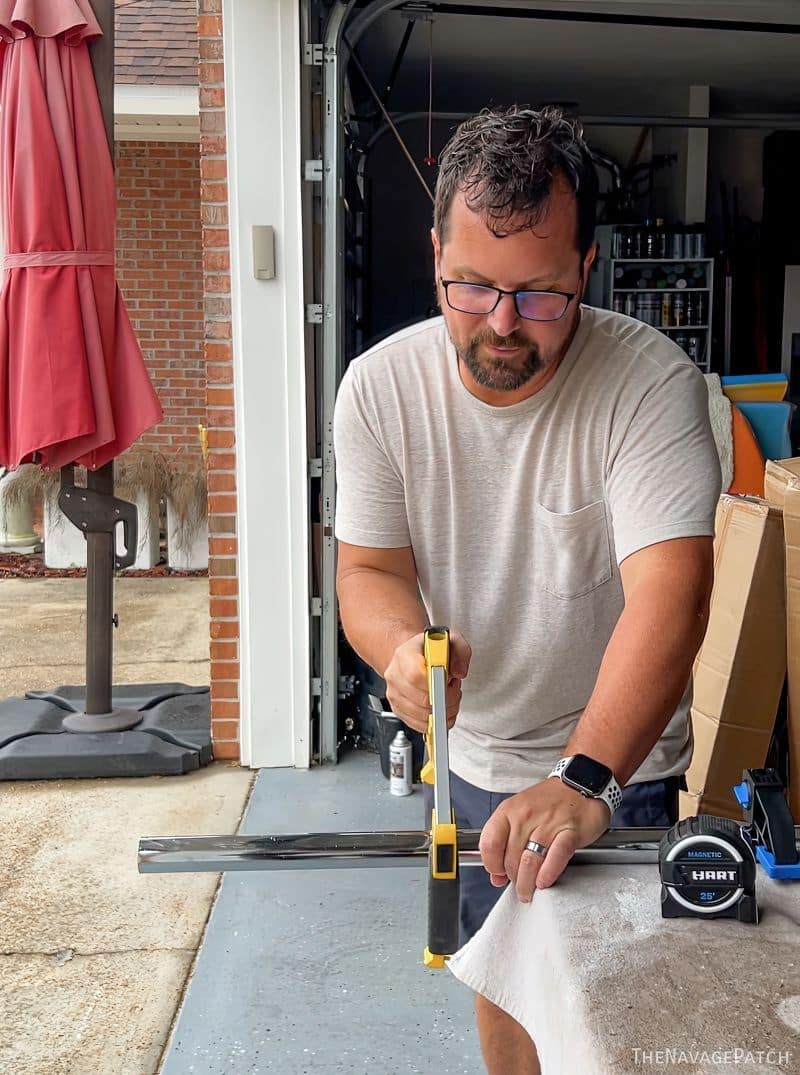 man cutting a closet pole