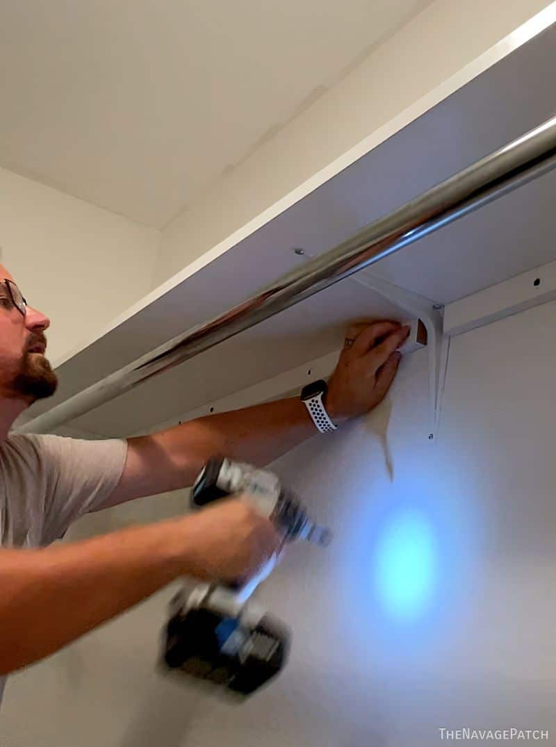 man installing a shelf in a closet