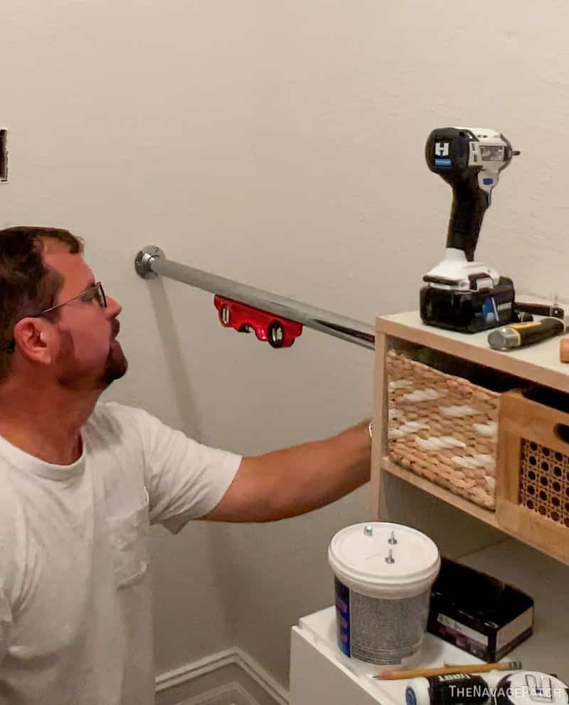 man hanging a closet pole