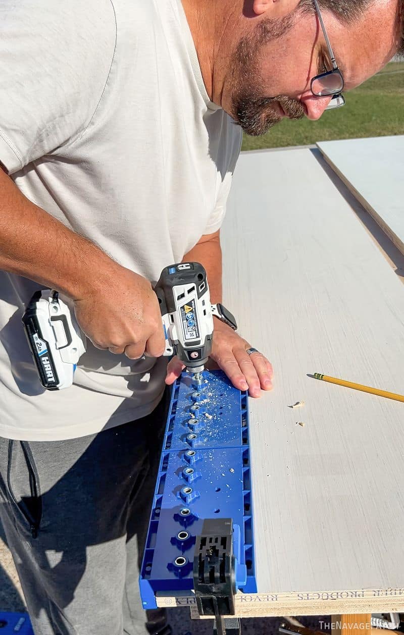 man drilling shelf pin holes