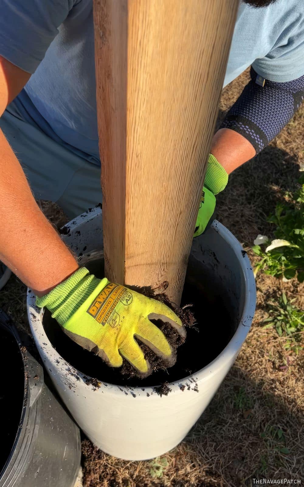 man putting soil into a planter